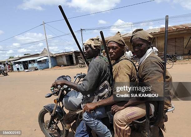 Traditional Ivorian Dozo hunters, members of the Binkadi association that gathers all Dozos in the region, ride a motorbike as they arrive on...