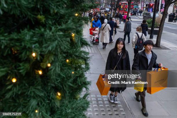 Shoppers are pictured outside department store Selfridges on Oxford Street a week before Christmas Day on 18th December 2023 in London, United...