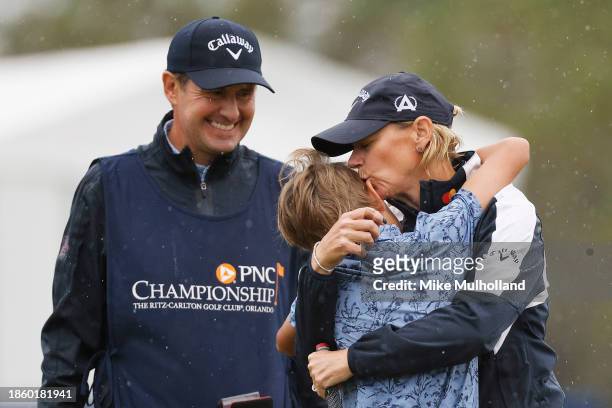 Annika Sorenstam of Sweden kisses her son Will McGee as husband Mike McGee looks on from the 18th green following the first round of the PNC...