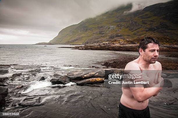 man stands shivering after wild swim in scotland - beef stockfoto's en -beelden
