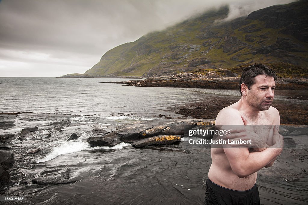 MAN STANDS SHIVERING AFTER WILD SWIM IN SCOTLAND