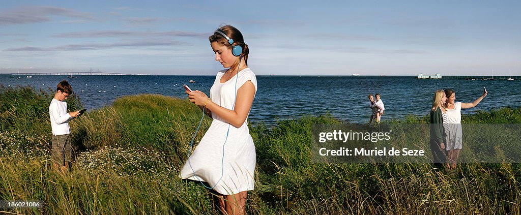 Young people using phones in nature.