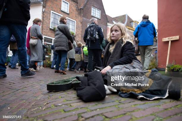 Girl dressed as a character from Charles Dickens' books begs on the street as she participates in the Dickens Festival on December 16, 2023 in...