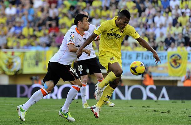 Valencia's midfielder Javi Fuego vies for the ball with Villarreal's Nigerian forward Ikechukwu Uche during the Spanish league football match...