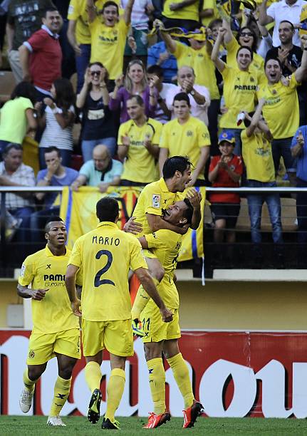 Villarreal's football players celebrate their second goal during the Spanish league football match Villarreal CF vs Valencia CF at the El Madrigal...