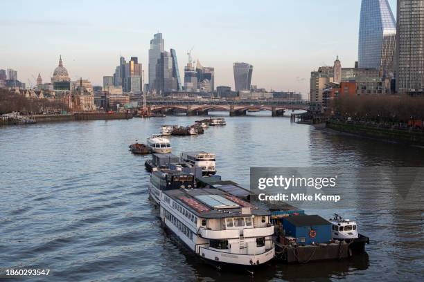 City of London skyline looking over the River Thames past moored boats on 6th December 2023 in London, United Kingdom. The City of London is a city,...