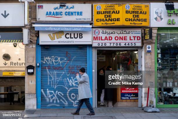Small business with shutters down next to an open Bureau de change on Edgware Road on 6th December 2023 in London, United Kingdom.