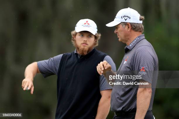 Retief Goosen of South Africa and his son Leo Goosen wait to putt on the ninth hole during the first round of the PNC Championship at The...