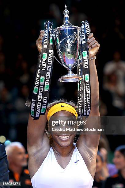 Serena Williams of the United States celebrates with the Billie Jean King Trophy after defeating Na Li of China during the final of the TEB BNP...