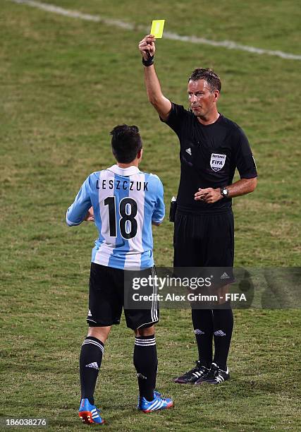 Refere Mark Clattenburg shows the yellow card to Luis Leszczuk of Argentina during the FIFA U-17 World Cup UAE 2013 Group E match between Argentina...