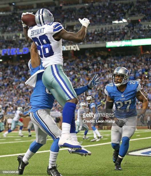 Dez Bryant of the Dallas Cowboys scores on a five yard touchdown pass from Tony Romo as Darius Slay and Glover Quin of the Detroit Lions defend...