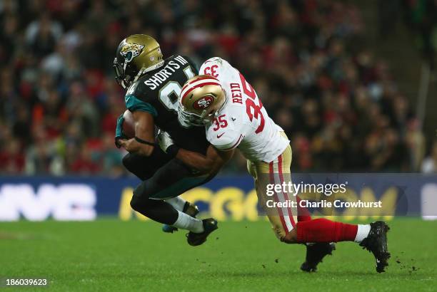 Cecil Shorts III of the Jacksonville Jaguars is tackled by Eric Reid of the San Francisco 49ers during the NFL International Series game between San...