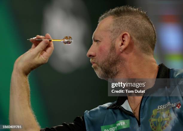 David Cameron of Canada throws in his First Round match against Jamie Hughes of England on Day Two of 2023/24 Paddy Power World Darts Championship at...