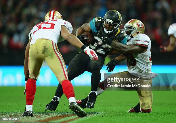 Maurice Jones-Drew of the Jacksonville Jaguars is tackled by Eric Reid of the San Francisco 49ers during the NFL International Series game between...