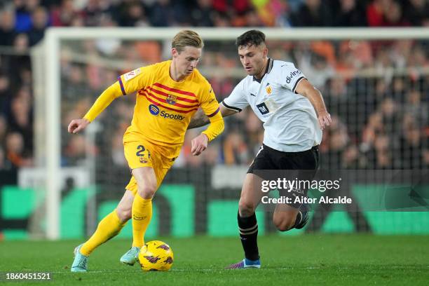 Frenkie de Jong of FC Barcelona runs with the ball whilst under pressure from Hugo Duro of Valencia CF during the LaLiga EA Sports match between...