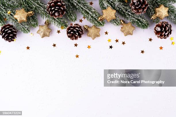 pine needles, pine cone and gold star shape winter christmas background with copy space - star confetti white background stockfoto's en -beelden