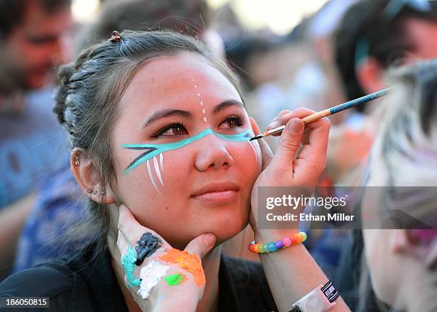 Tharika Yoe of Nevada gets her face painted during a set by recording artist Robert DeLong at the Life is Beautiful festival on October 27, 2013 in...