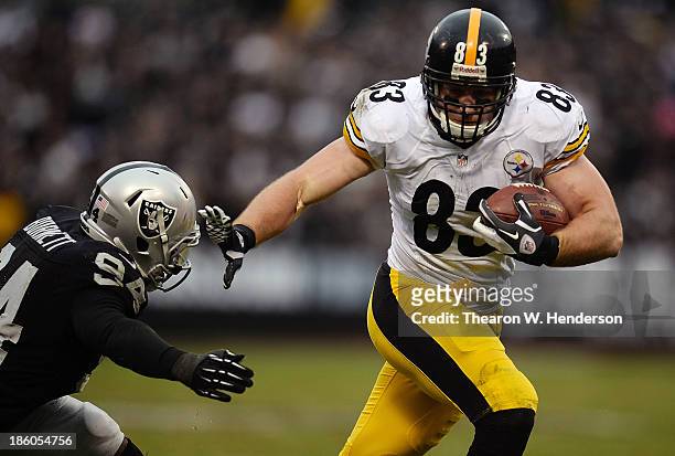 Heath Miller of the Pittsburgh Steelers stiff arms Kevin Burnett of the Oakland Raiders and gets down to the four yard line during the fourth quarter...