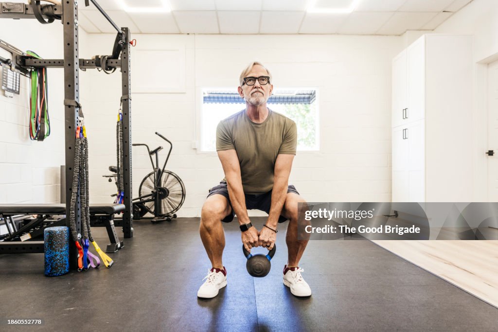 Senior man using kettle ball at physical therapy