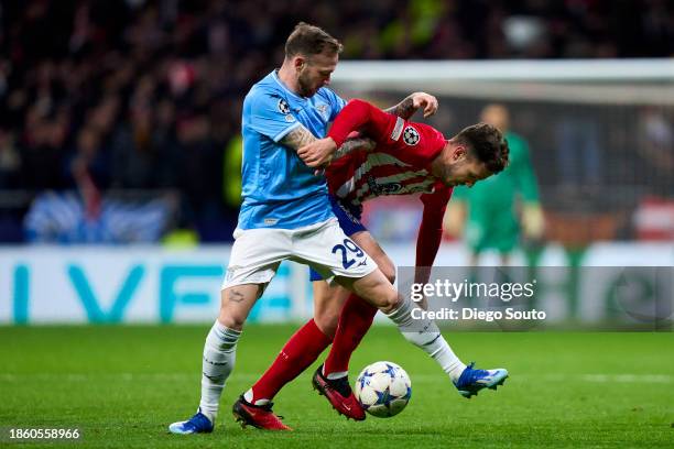 Saul Niguez of Atletico Madrid battle for the ball with Manuel Lazzari of SS Lazio during the UEFA Champions League match between Atletico Madrid and...