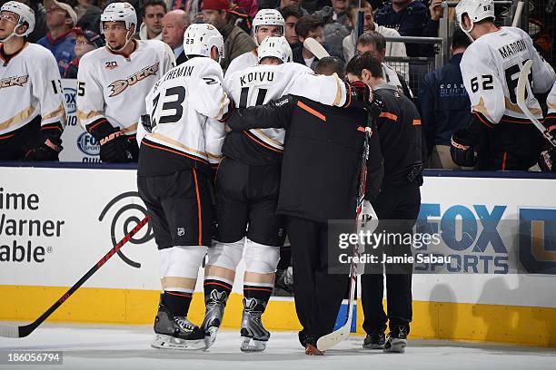 Saku Koivu of the Anaheim Ducks is helped off the ice after colliding with Brandon Dubinsky of the Columbus Blue Jackets during the second period on...