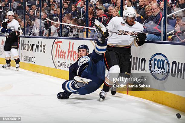 Devante Smith-Pelly of the Anaheim Ducks attempts to gain possession of the puck as David Savard of the Columbus Blue Jackets falls to the ice during...