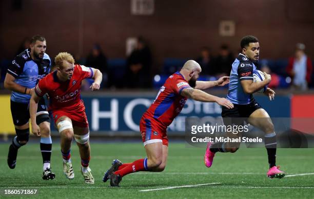 Ben Thomas of Cardiff Rugby runs with the ball whilst under pressure from Tom Dunn of Bath Rugby during the Investec Champions Cup match between...
