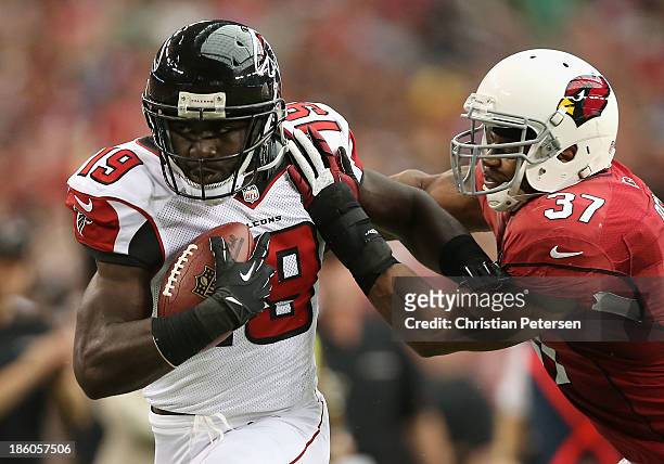 Wide receiver Drew Davis of the Atlanta Falcons runs with the football after a reception past strong safety Yeremiah Bell of the Arizona Cardinals...