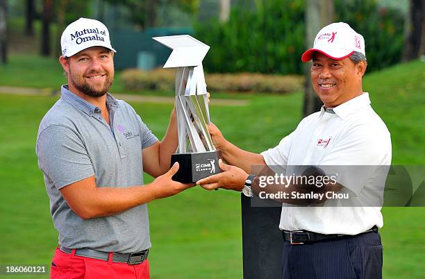 Ryan Moore of the United States receives the CIMB Classic Trophy from the Deputy Prime Minister of Malaysia, Tan Sri Muhyiddin Yassin after he won...