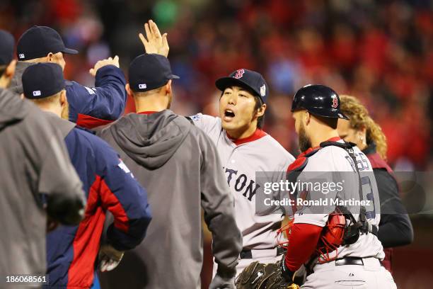 Koji Uehara of the Boston Red Sox celebrates with his teammates after throwing out Kolten Wong of the St. Louis Cardinals to win Game Four of the...