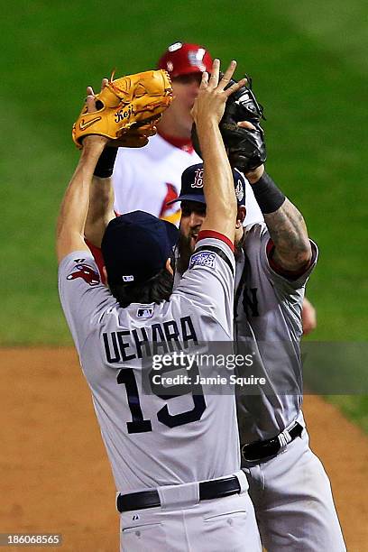 Koji Uehara of the Boston Red Sox celebrates with teammate Mike Napoli after throwing out Kolten Wong of the St. Louis Cardinals to win Game Four of...