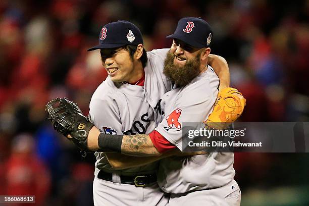 Koji Uehara of the Boston Red Sox celebrates with teammate Mike Napoli after throwing out Kolten Wong of the St. Louis Cardinals to win Game Four of...