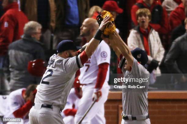 Koji Uehara of the Boston Red Sox celebrates with teammate Mike Napoli after throwing out Kolten Wong of the St. Louis Cardinals to win Game Four of...