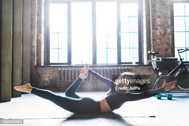 yoga instructor practicing bow posture in gym - self improvement stock pictures, royalty-free photos & images