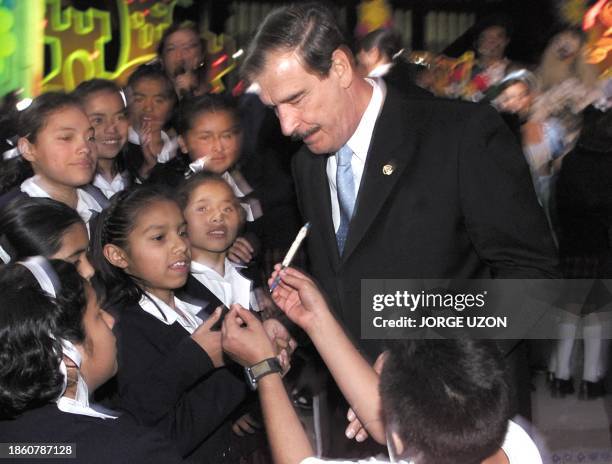 President Vicente Fox sign autographs for kids in Mexico City 07 January 2002. El presidente de Mexico Vicente Fox firma autografos tras finalizar un...