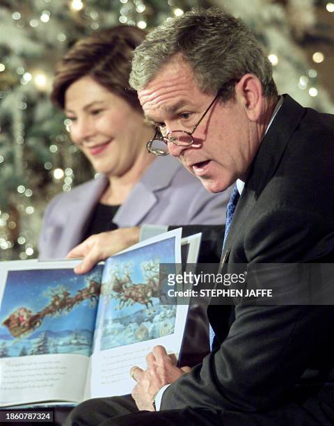 First Lady Laura Bush watches US President George W. Bush read "'Twas the Night Before Christmas" to first grade students from Hoffman-Boston...
