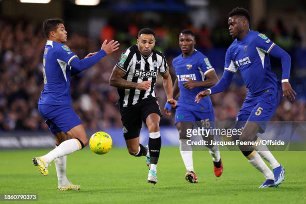 Callum Wilson of Newcastle United forces his way between Thiago Silva of Chelsea and Benoit Badiashile of Chelsea during the Carabao Cup Quarter...