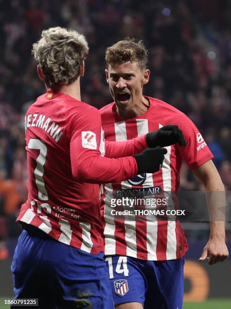Atletico Madrid's French forward Antoine Griezmann celebrates with Atletico Madrid's Spanish midfielder Marcos Llorente after scoring his team's...