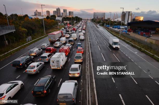 Traffic queues on a main route into London by the towers of London's financial district Canary Wharf on October 28, 2013 after a strong storm causes...