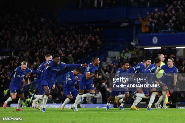 Chelsea's team players celebrate after Chelsea's Serbian goalkeeper Djordje Petrovic saved a penalty kick during the penalty shoot out to win the...