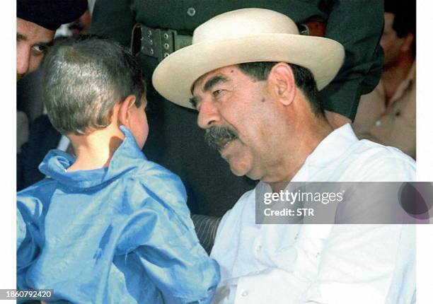 Iraqi President Saddam Hussein plays with an Iraqi child 16 September in the area of Salahuddin, near his birthplace in Tikrit. The Iraqi news agency...