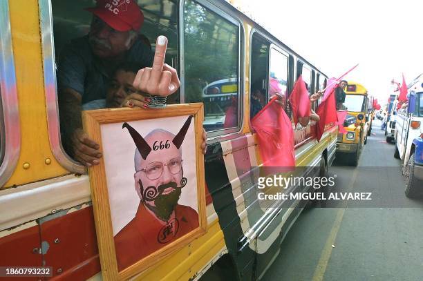 Supporters of Nicaraguan ex-president Arnoldo Aleman, honorary president of the Partido Liberal Constitucionalista , show a grafitied photo of...