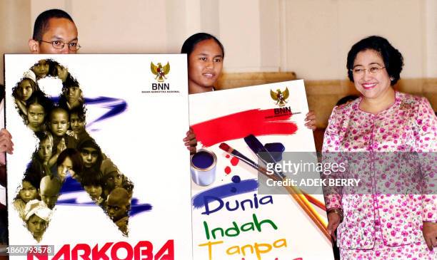 Indonesian president Megawati Sukarnoputri stands beside anti drugs posters at the presidential palace in Jakarta 26 June 2002. Megawati on Wednesday...