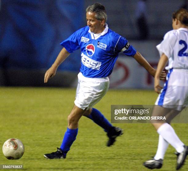 Honduran President, Ricardo Maduro , is guarded by an unidentified member of the Diplomatic team, during a fund raising soccer match for the San...