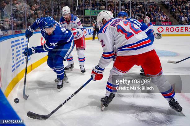 Bobby McMann of the Toronto Maple Leafs battles for the puck against Nick Bonino of the New York Rangers during the first period at Scotiabank Arena...