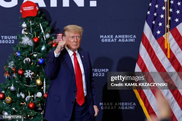 Former US President and 2024 presidential hopeful Donald Trump gestures at the end of a campaign event in Waterloo, Iowa, on December 19, 2023. An...