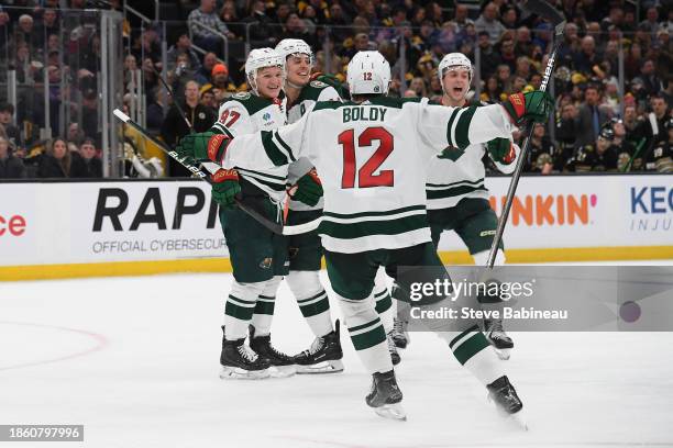 Matt Boldy, Kirill Kaprizov and Joel Eriksson Ek of the Minnesota Wild celebrate the third-period goal against the Boston Bruins on December 19, 2023...