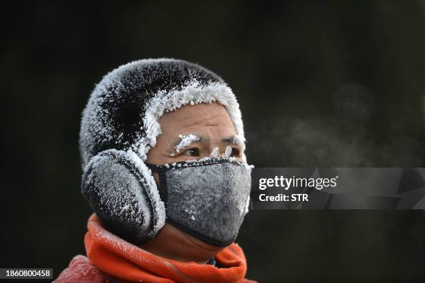 Resident is covered in frost while exercising outdoors during cold weather in Shenyang, in China's northeast Liaoning province on December 20, 2023....