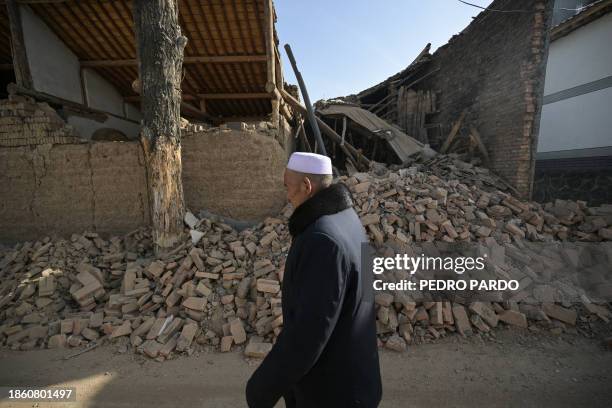 Man walks past a damaged building after an earthquake at Gaoli village in Jishishan County in northwest China's Gansu province on December 20, 2023....