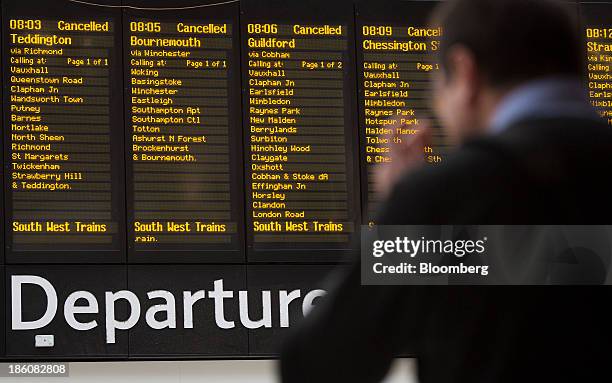 Information boards display cancelled train departures due to adverse weather conditions as commuters wait at Waterloo train station in London, U.K.,...